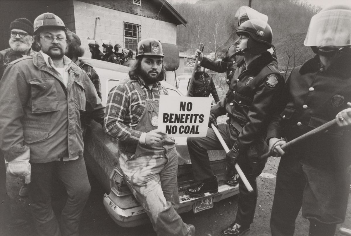 Young men on trike holding a sign.