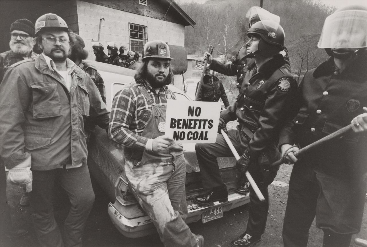 Young men on trike holding a sign.