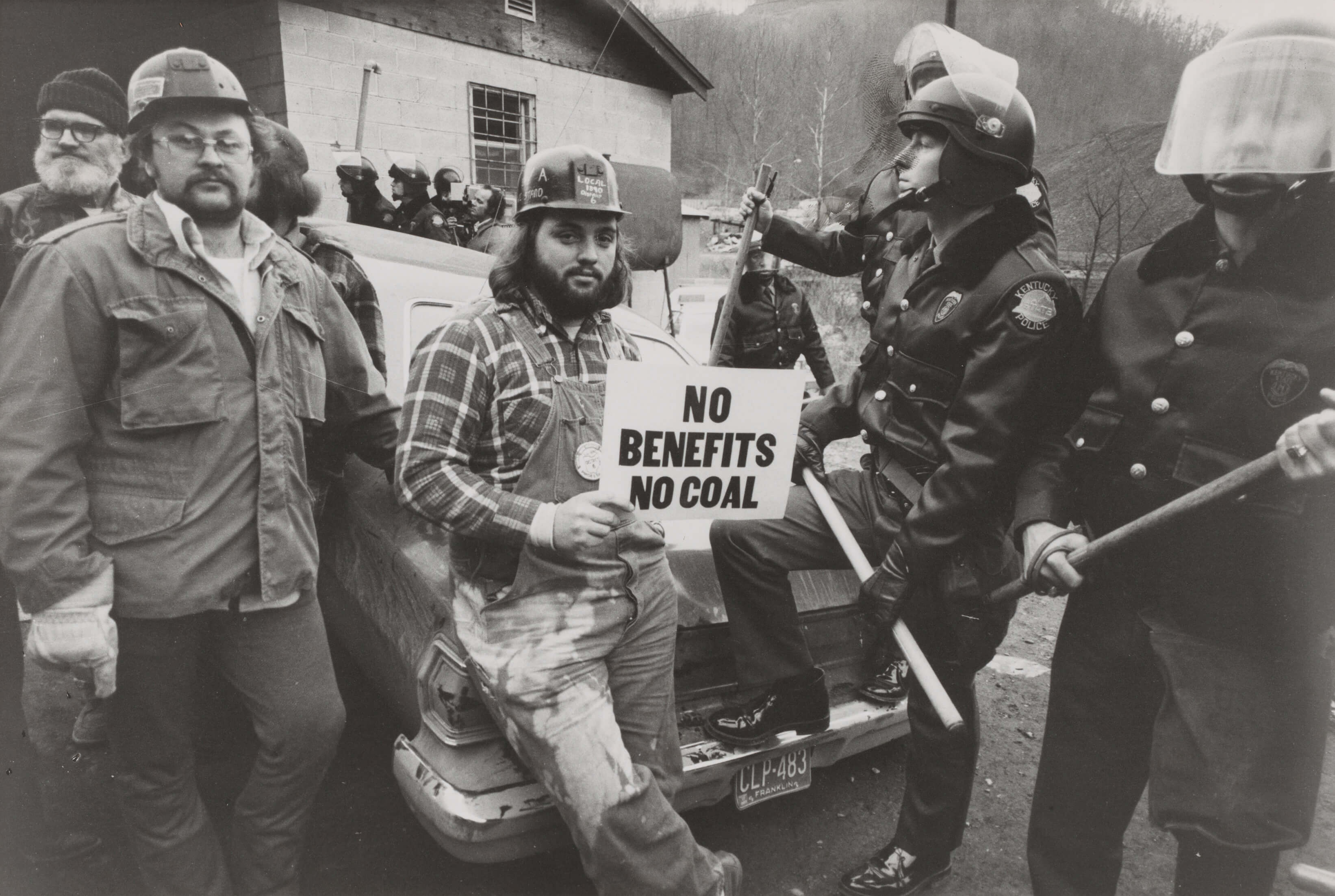 Young men on trike holding a sign. 