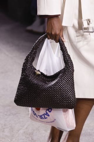 a model carrying a bottega veneta intrecciato bag