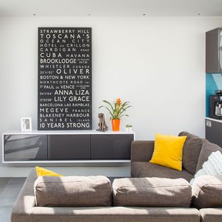 living area with white wall and grey sofa and white wall