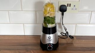Nutribullet Magic Bullet Kitchen Express on a kitchen countertop filled with fruit and vegetables ready to blend into a smoothie