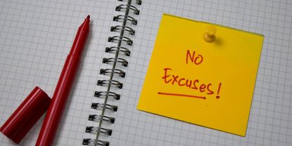 A notebook with a Post-It note that reads No Excuses!