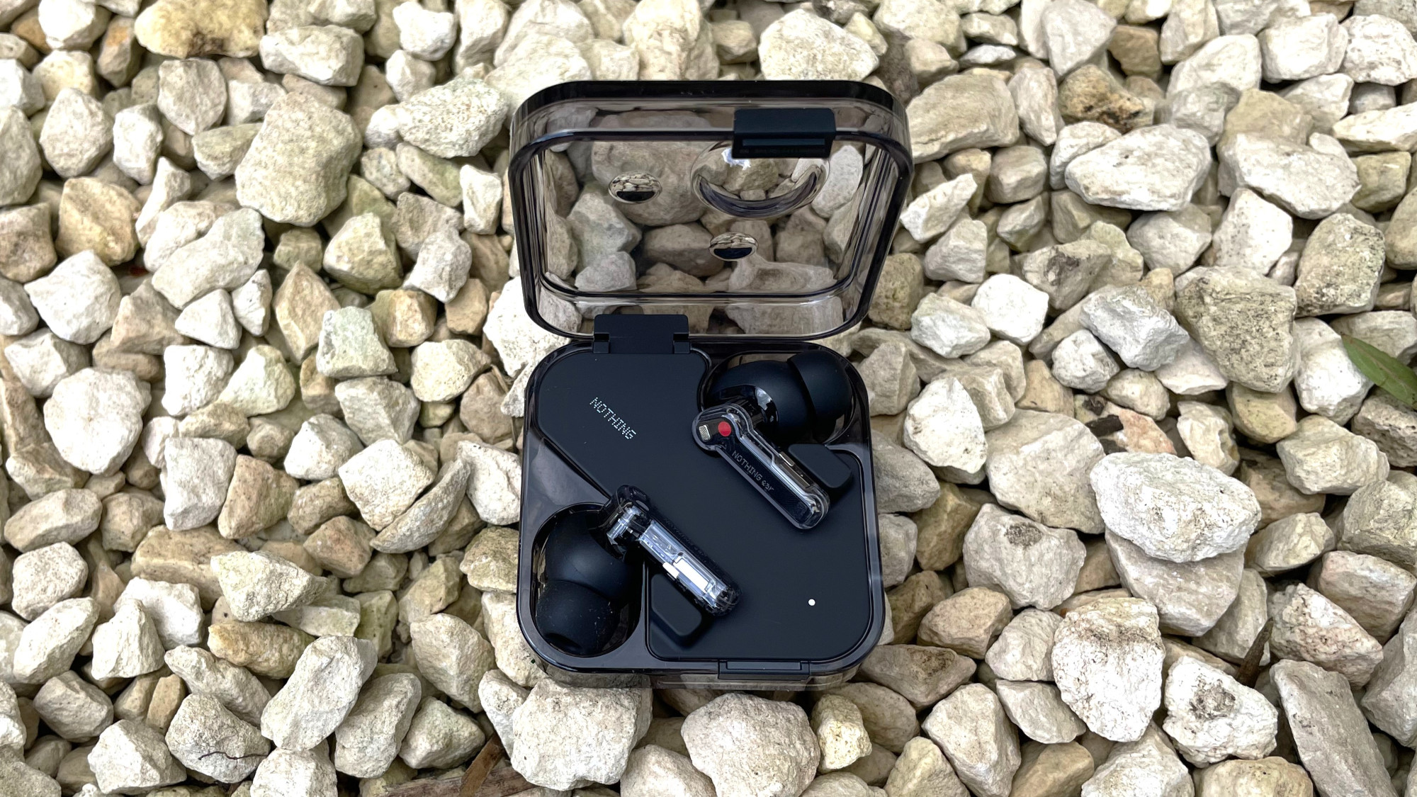 Nothing Ear 2024 in black in charging case on stones