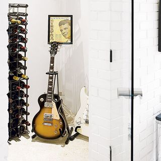 room with white wall and wine and guitar