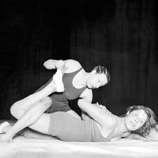 Black & white photograph of man pinning woman down in wrestling hold