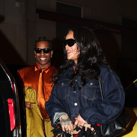 Rihanna wearing a dark denim cropped jacket, cropped denim jeans, and strappy heels