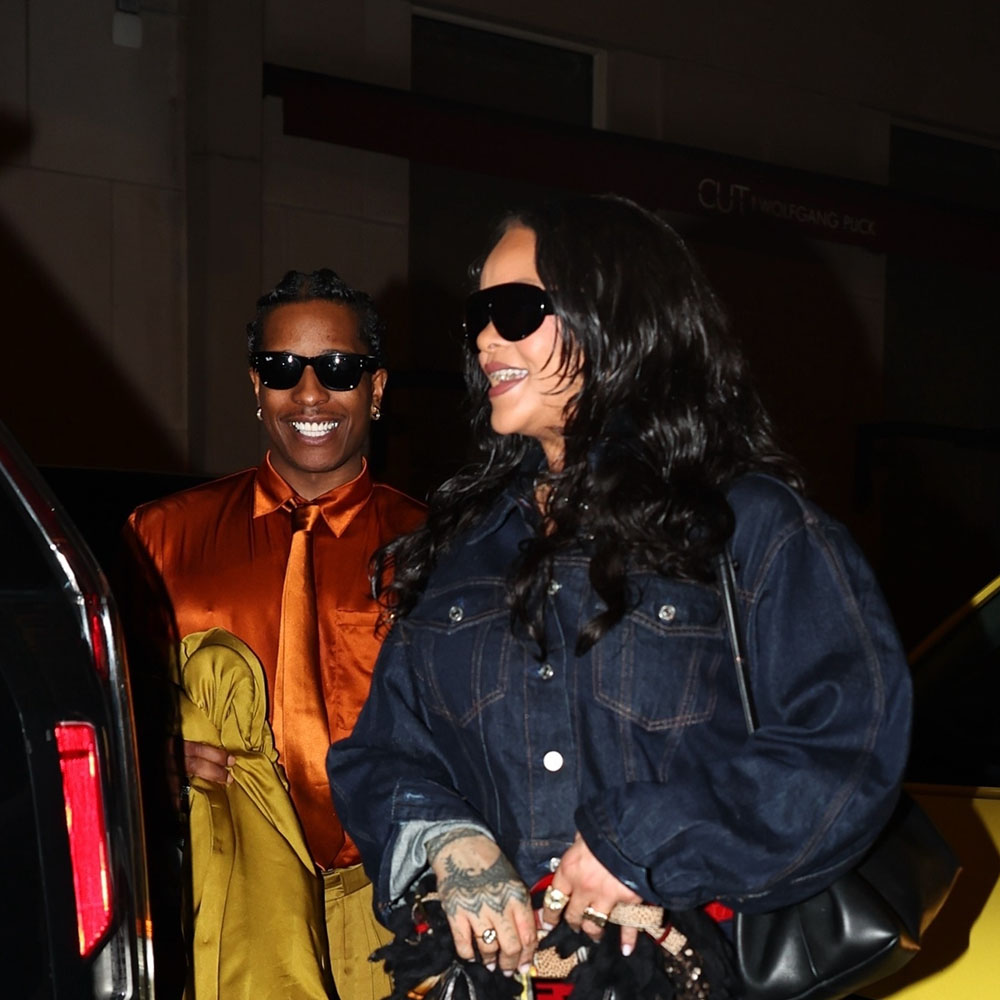Rihanna wearing a dark denim cropped jacket, cropped denim jeans, and strappy heels