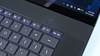 Close-up of the ASUS ProArt P16 keyboard deck highlighting the circular power button centered above backlit function keys and speaker grille.