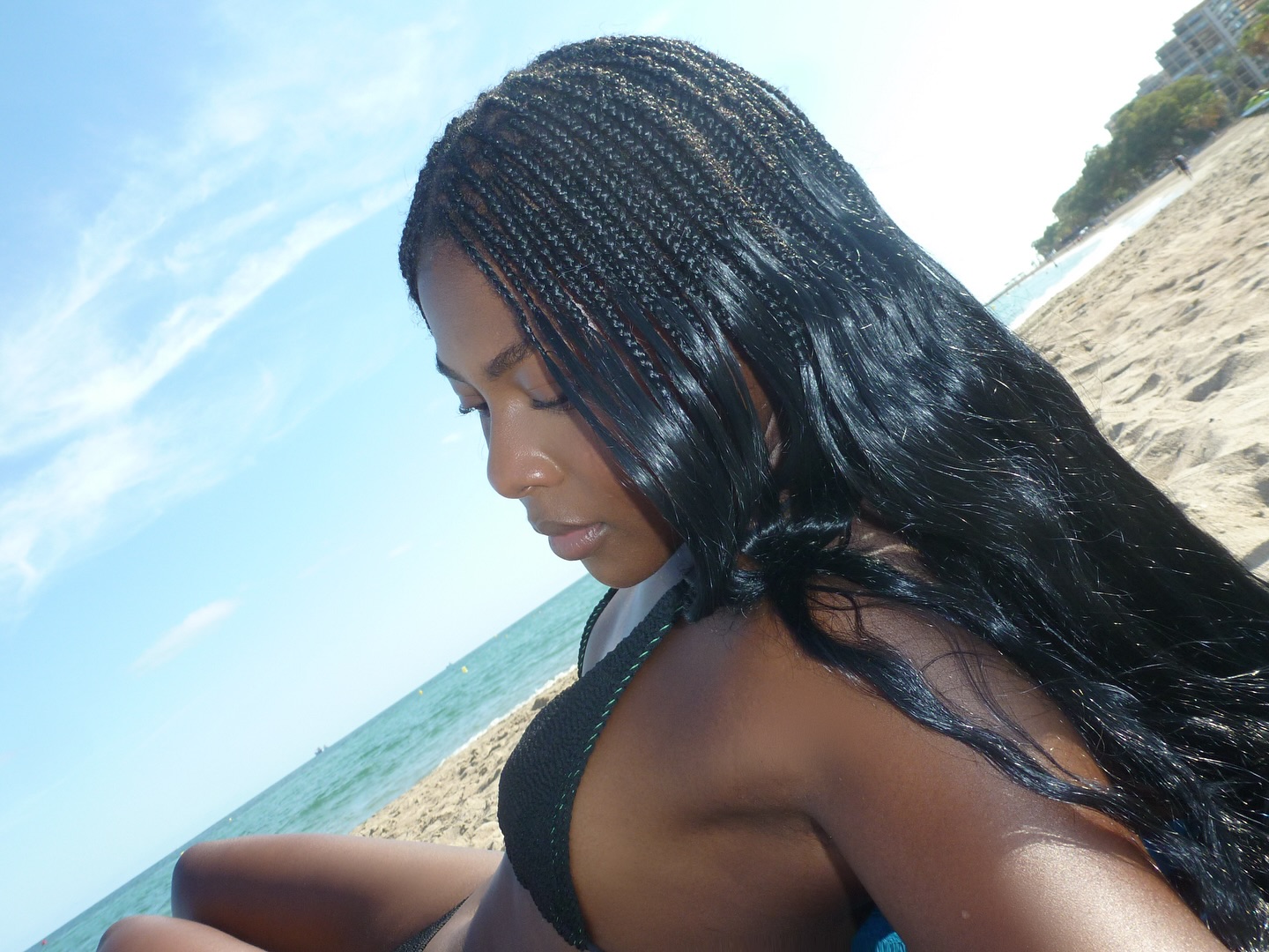 A woman on the beach with shiny hair.