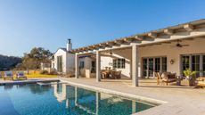 a large pool deck in dripping springs, texas with an outdoor kitchen, dining and seating area
