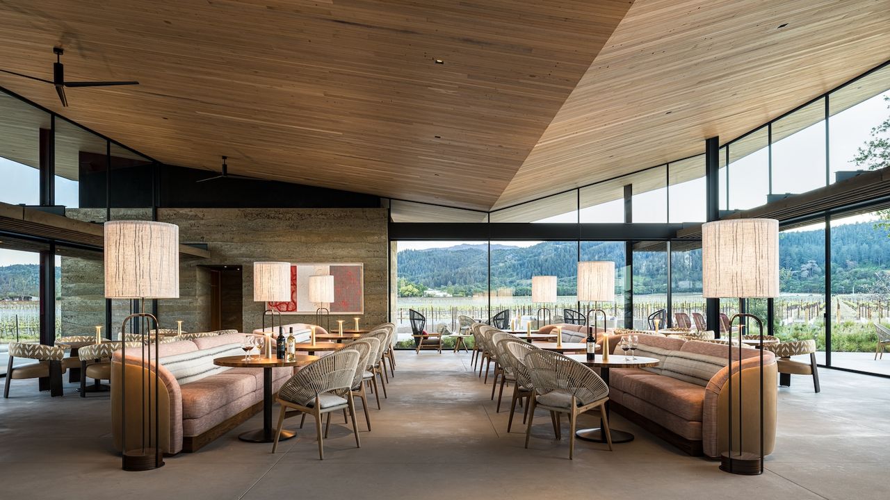 Robert Mondavi Winery's new Vineyard Room, set up for tastings, with floor to ceiling windows looking out at the estate vineyard.