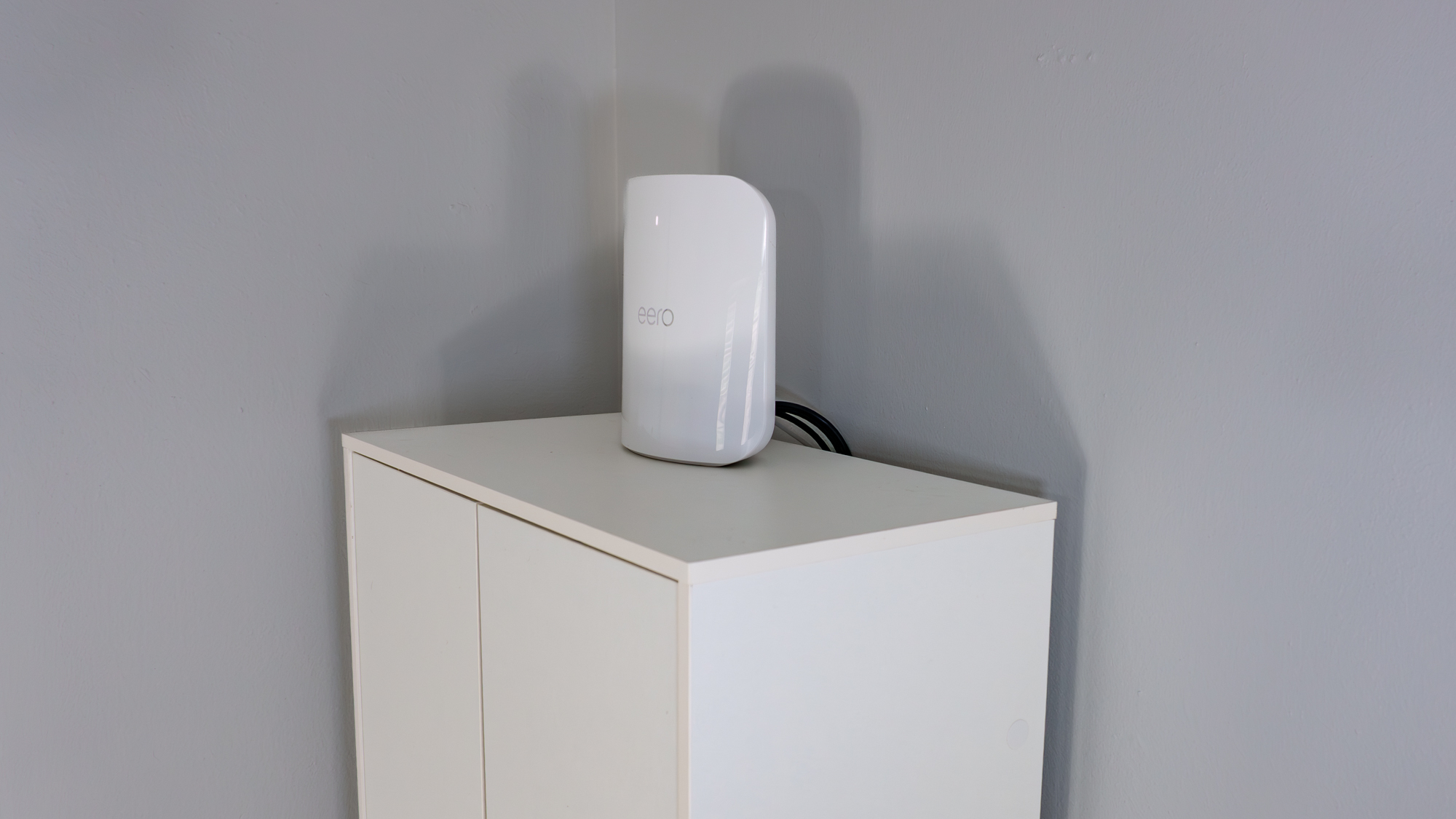 An eero Max 7 mesh router on top of a kitchen pantry cabinet