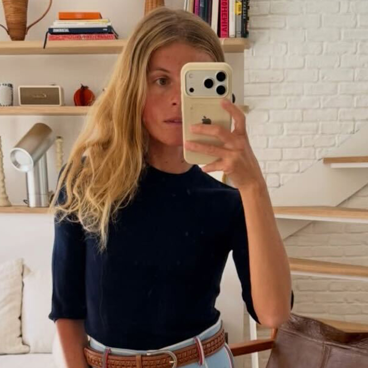 alice wears a black shirt with a woven belt.