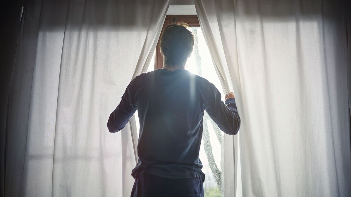 Man opening curtains