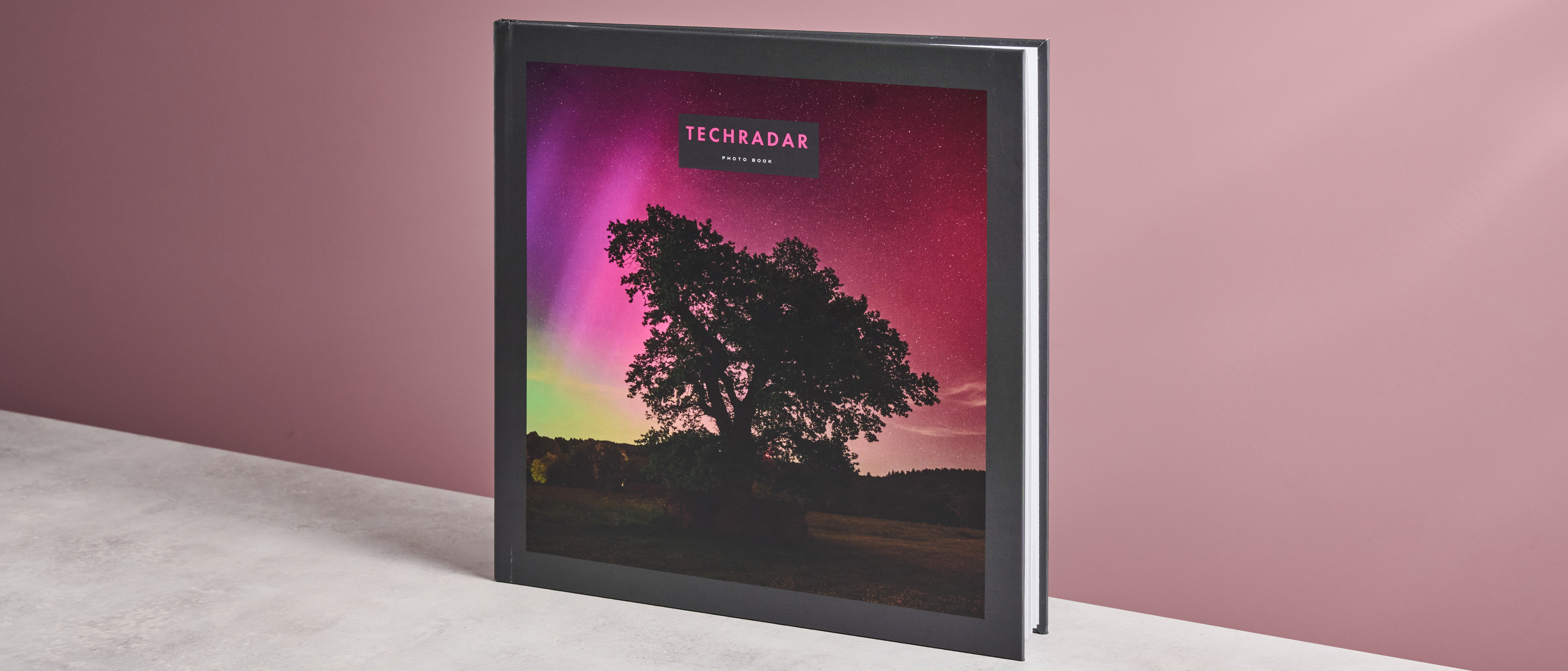 The cover of TechRadar&#039;s Papier photo book, featuring a tree in front of an aurora.