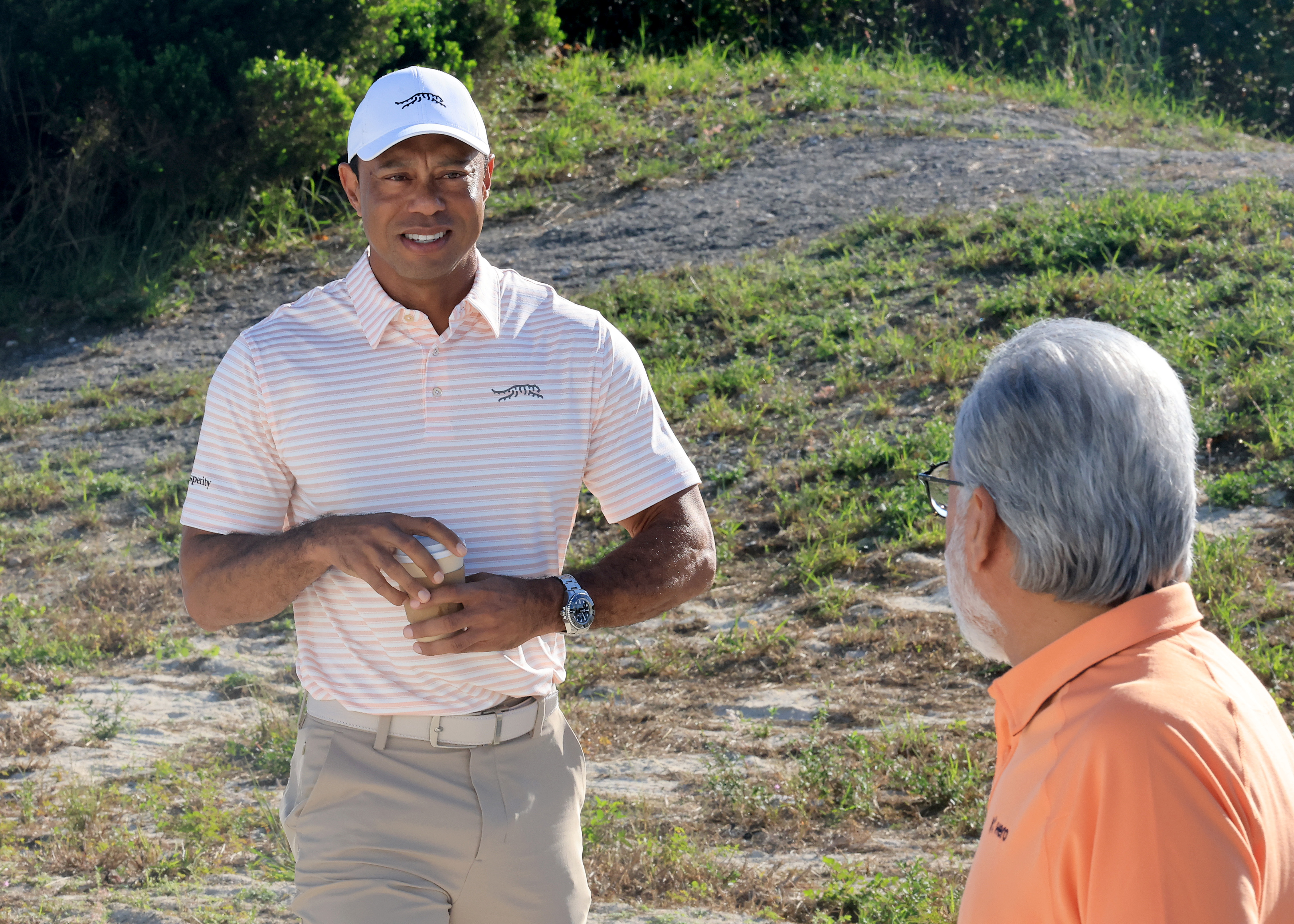 Tiger Woods looks at Dr Pawan Munjal, Executive Chairman, Hero MotoCorp ahead of the 2025 Hero World Challenge
