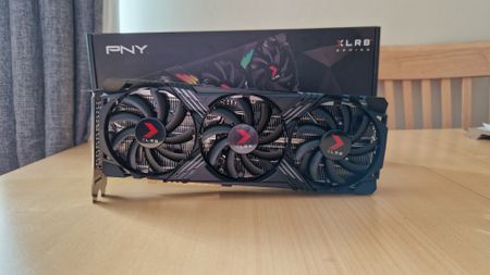 PNY GeForce RTX 4070 hero image of the GPU sitting diagonally on a table in front of its box