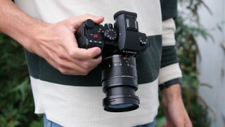 Panasonic Lumix G9 II camera held in a hand at waist height