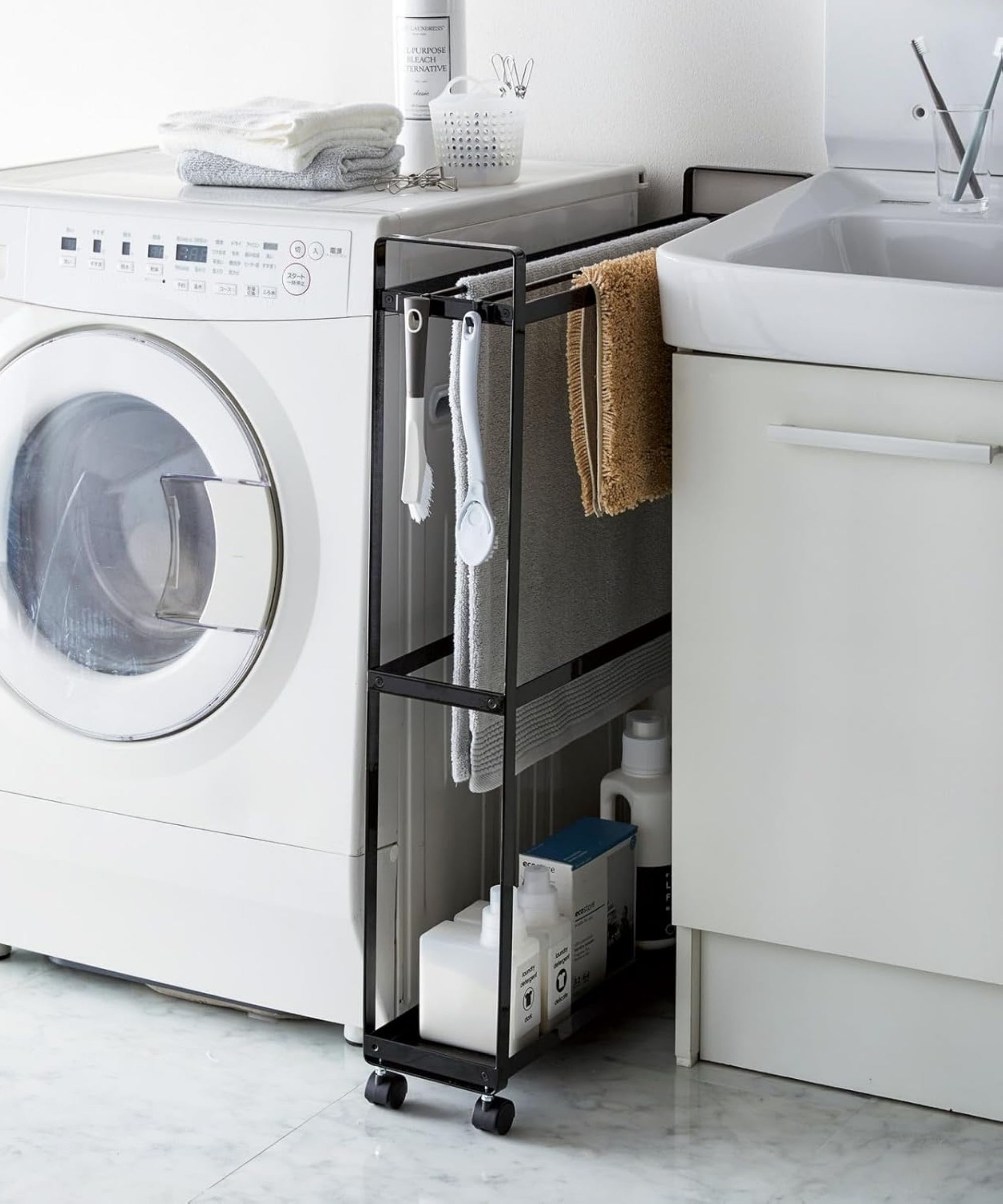 A slimline towel hanging rack stashed between a washing machine and a sink