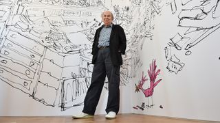 Quentin Blake in front of his illustrations