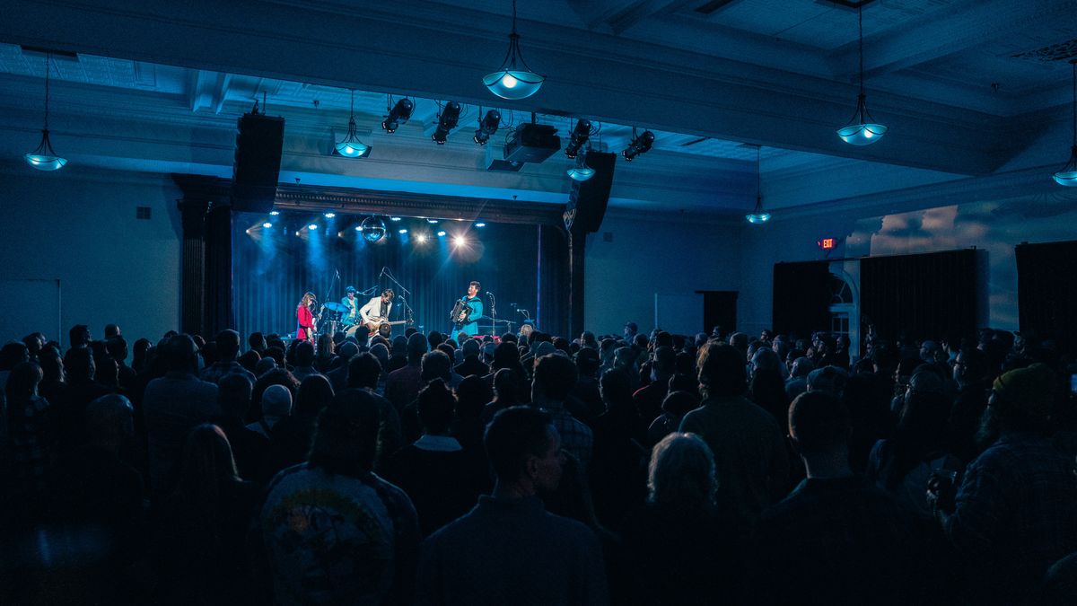 Blue, red, and purple lights shine on a live band as concertgoers stand and enjoy what WSDG helped bring to Hudson Valley’s newest live performance hub.