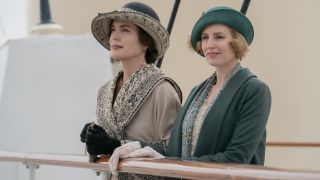 Elizabeth McGovern and Laura Carmichael lean on the railing of a ship in Downton Abbey: A New Era.