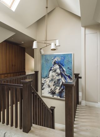 Landing with neutral decor, artwork of mountain, and pendant light