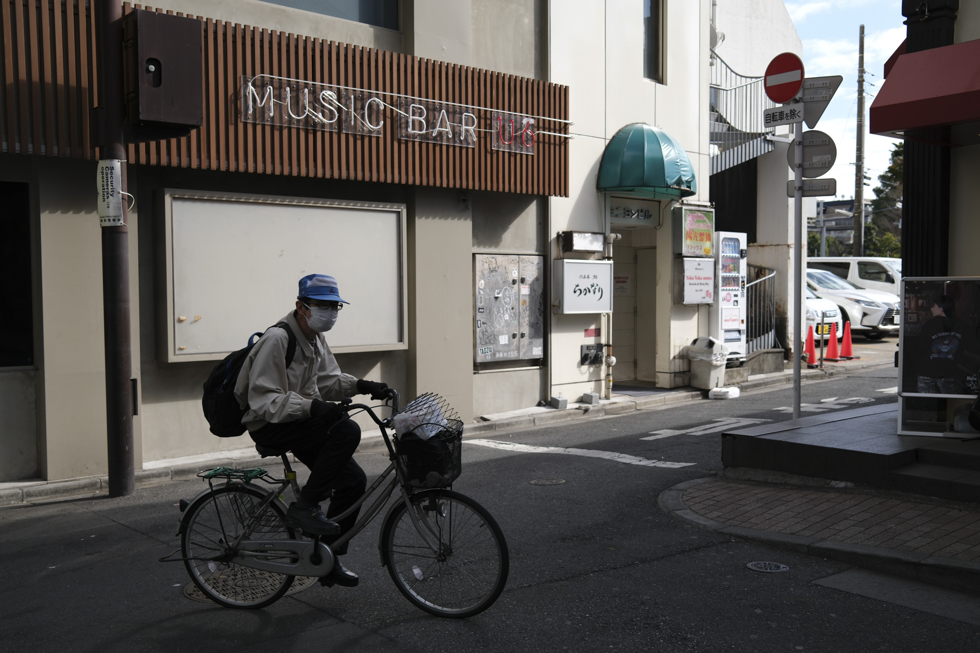 Tokyo city in the day, elederly man cycles past
