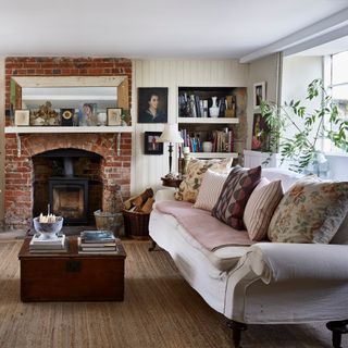 country living room with brick fireplace with wood burner, tongue and groove, neutral sofa with mixed cushions