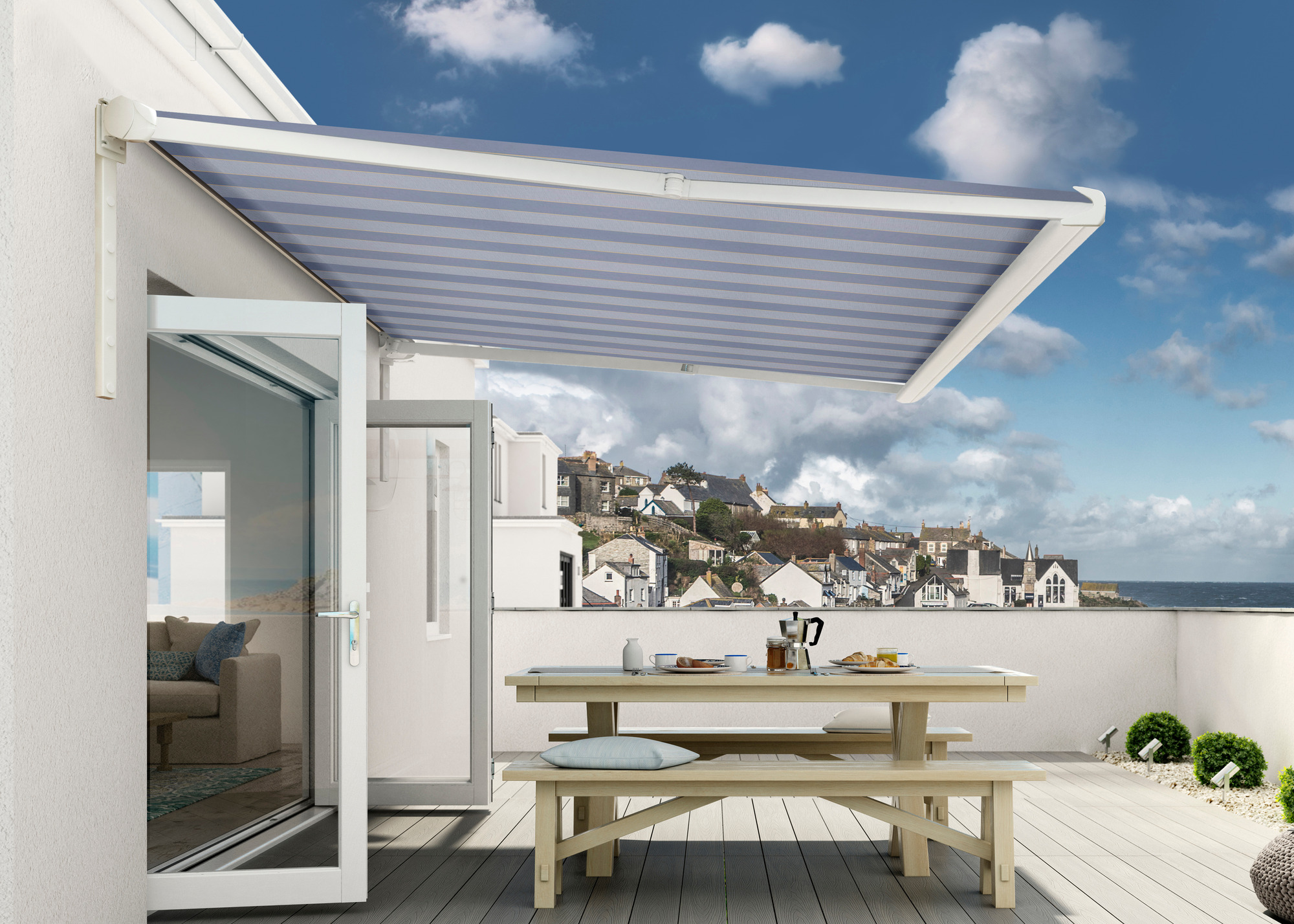 blue and white stripe retractable awning over a large balcony with wooden table and benches