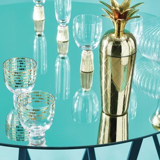 cocktail shaker and glasses on glass table