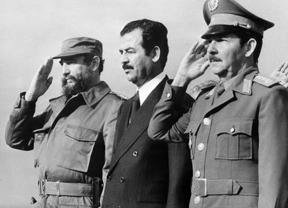 Iraqi vice-president Saddam Hussein (C), stands with Cuban President Fidel Castro (L) and Defense minister General Raul Castro (R)