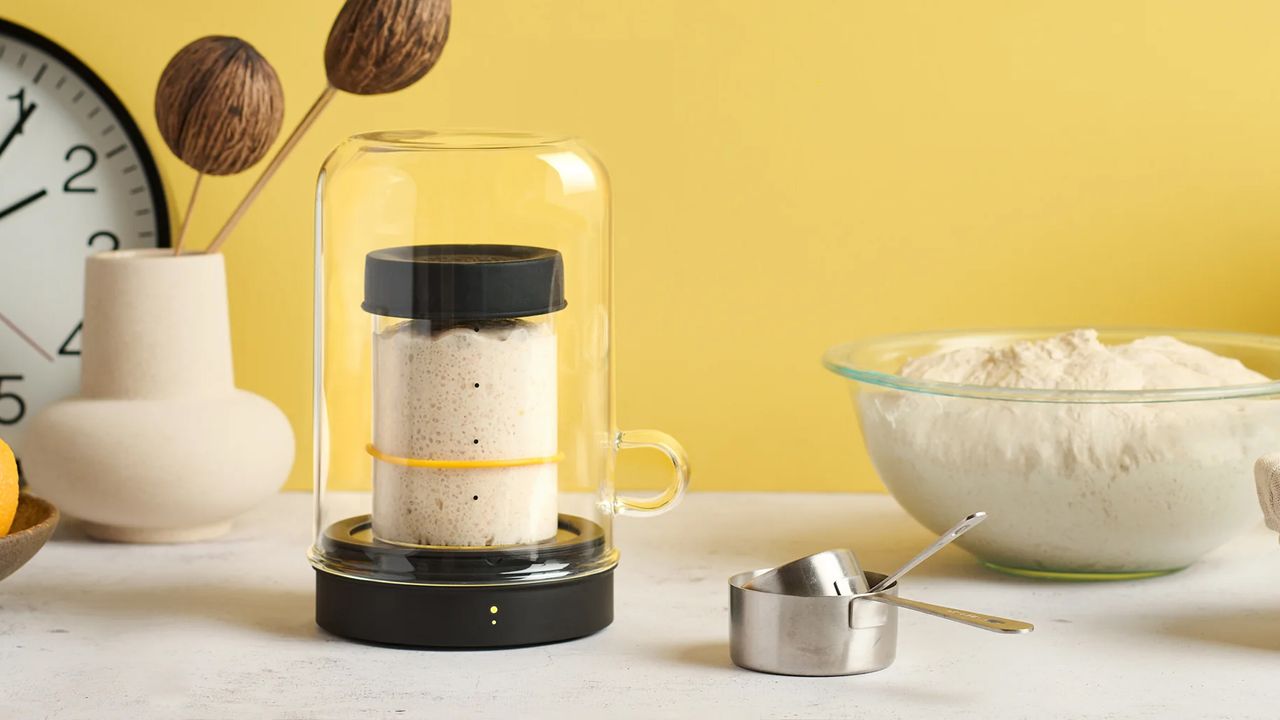 A sourdough starter keeper, whcih consists of a glass jar with a smaller container containing the starter inside of it 