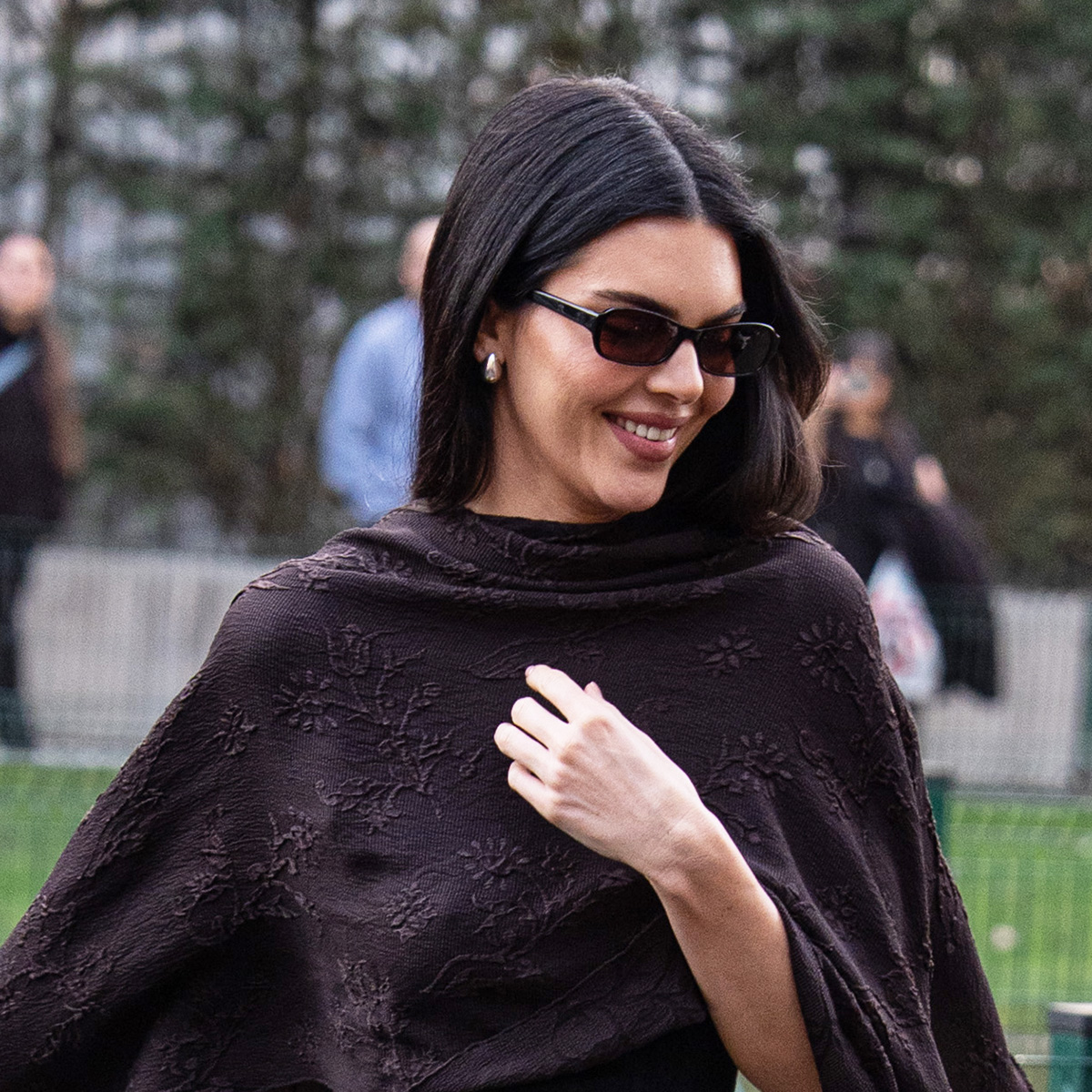 Kendall Jenner wearing a silk, cape, fitted dress, and strappy high-heel sandals in Milan.