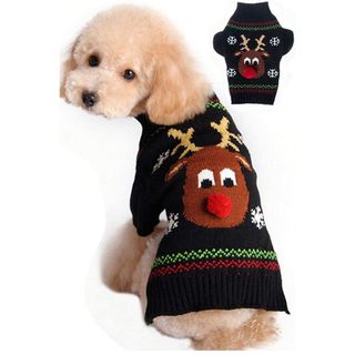 A small dog wearing a black sweater with a reindeer face on the back of the sweater with a red puff ball nose, for Christmas sweaters for dogs.