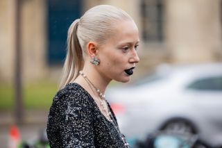 A guest wears black lipstick, earring outside Chanel during the Haute Couture Spring/Summer 2024 as part of Paris Fashion Week on January 23, 2024 in Paris, France.
