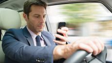 a businessman texts while driving his car