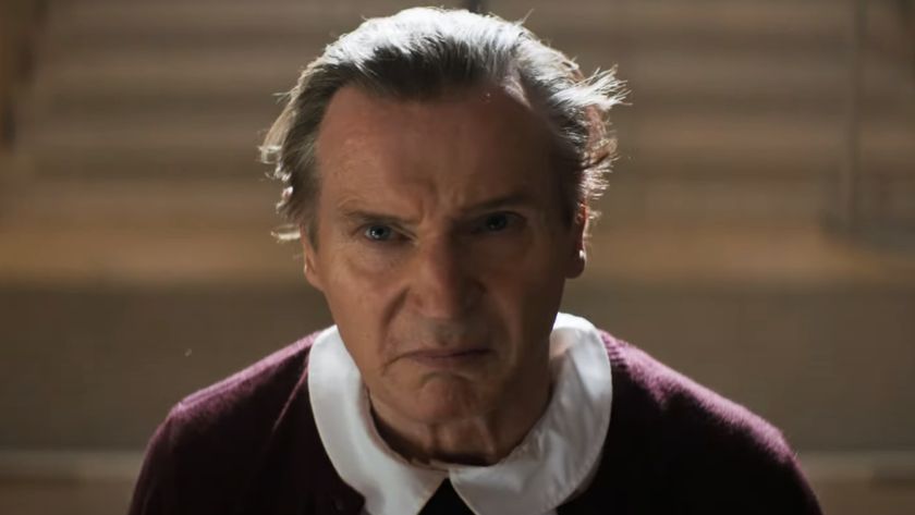 Liam Neeson looks up frowning after removing his little girl mask in The Naked Gun.