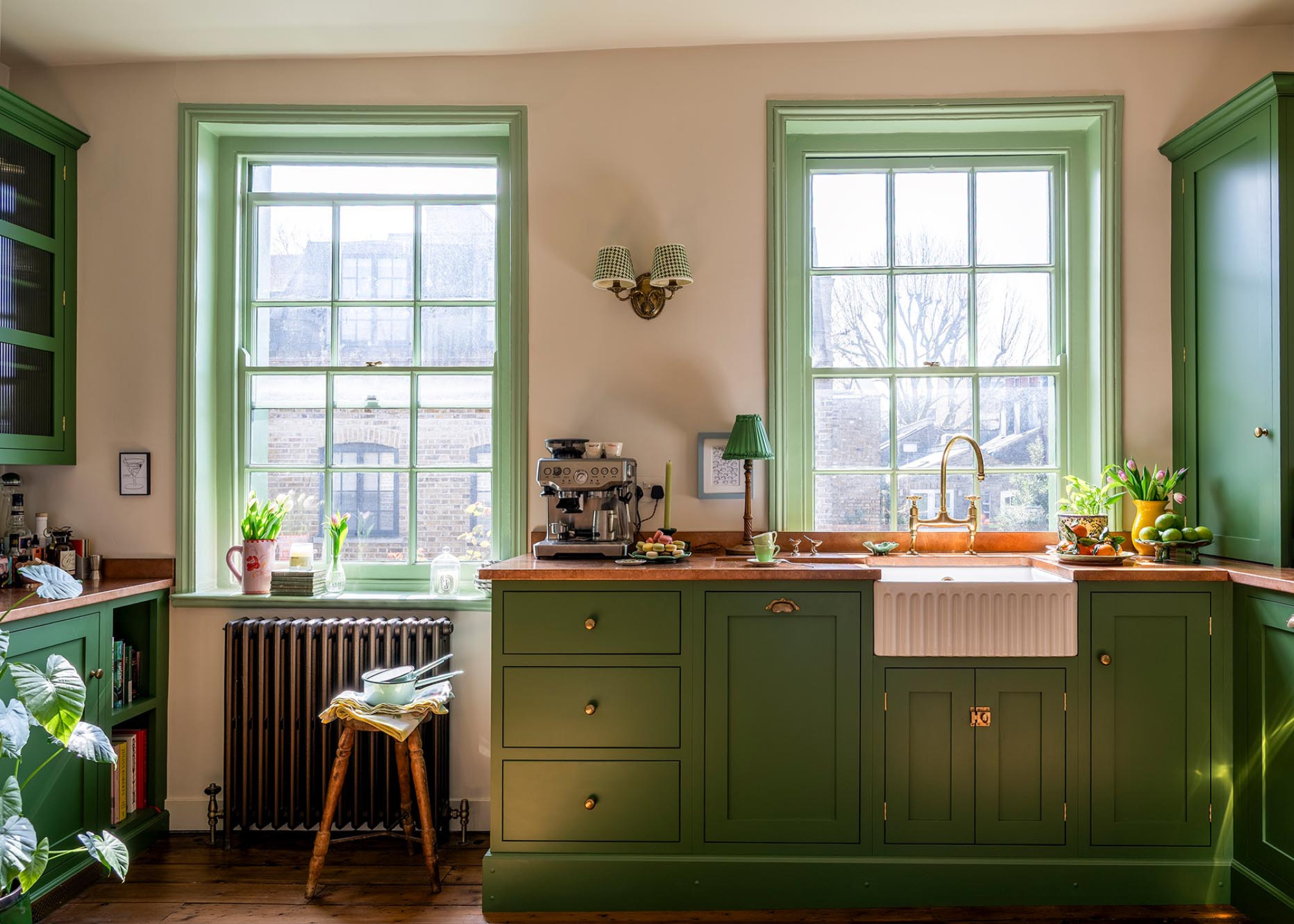 A traditional green kitchen with two sash windows