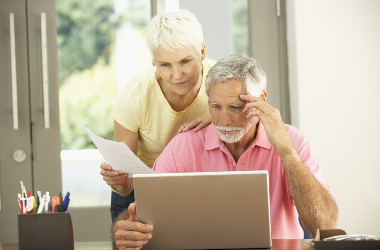 Worried Senior Couple Using Laptop At Home