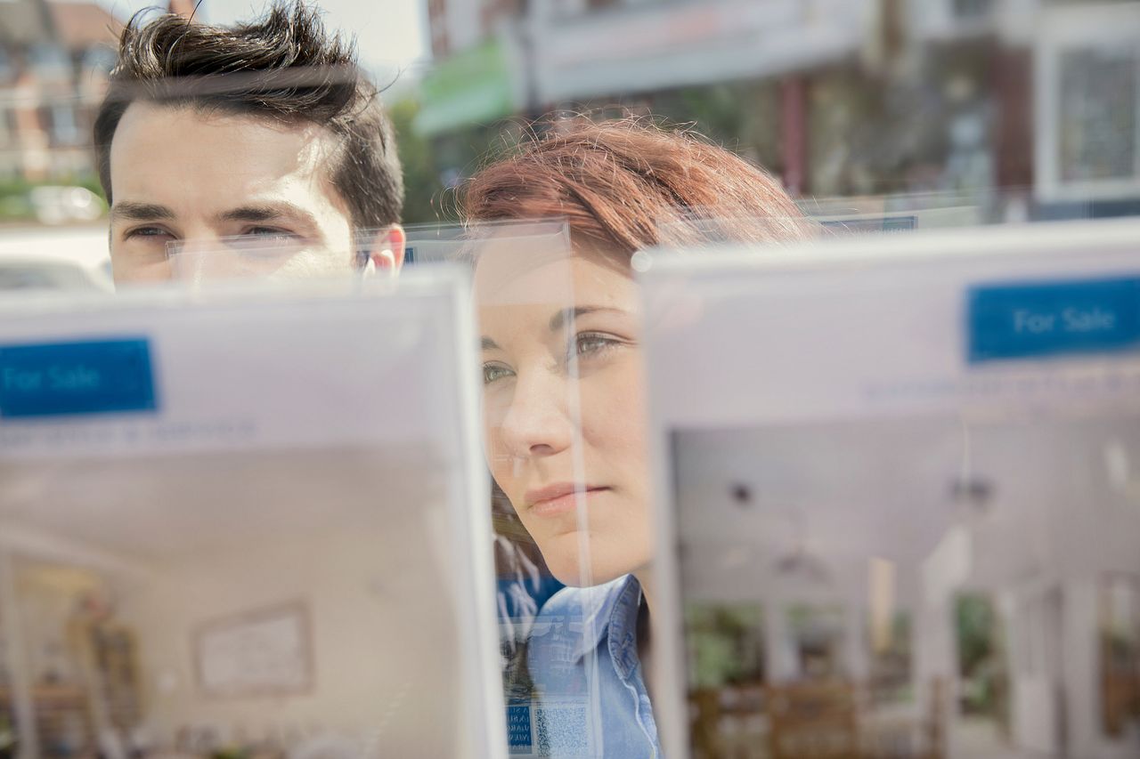 Couple looking at estate agent window