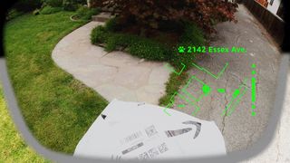 A mock up of what it would look like to wear Amazon Amelia smart glasses as a delivery driver, with a bright green HUD
