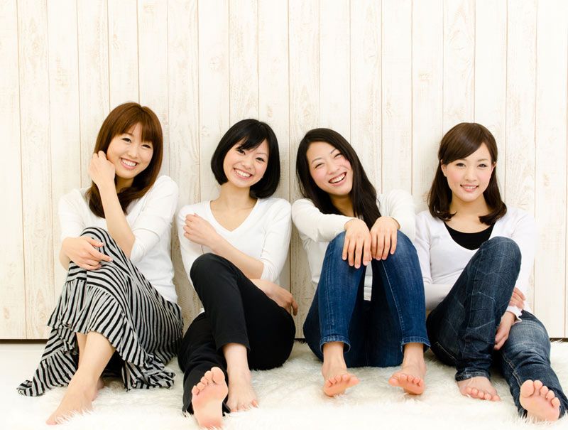 Four Asian women smiling.