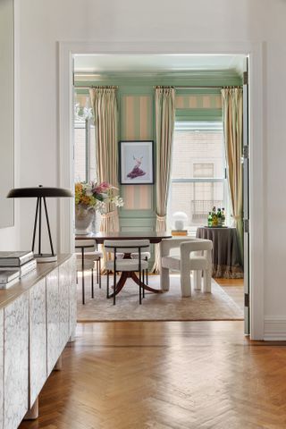 formal dining room painted mint green with yellow drapes and boucle armchairs