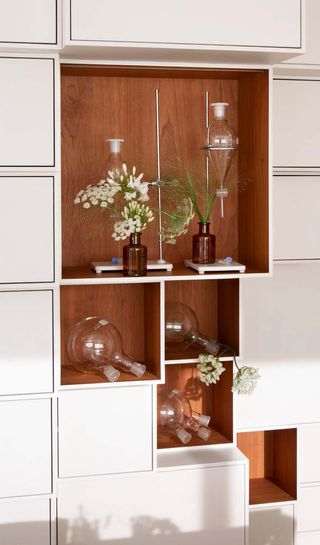 Glass vessels on shelves at fragrance laboratory of Mathilde Laurent 