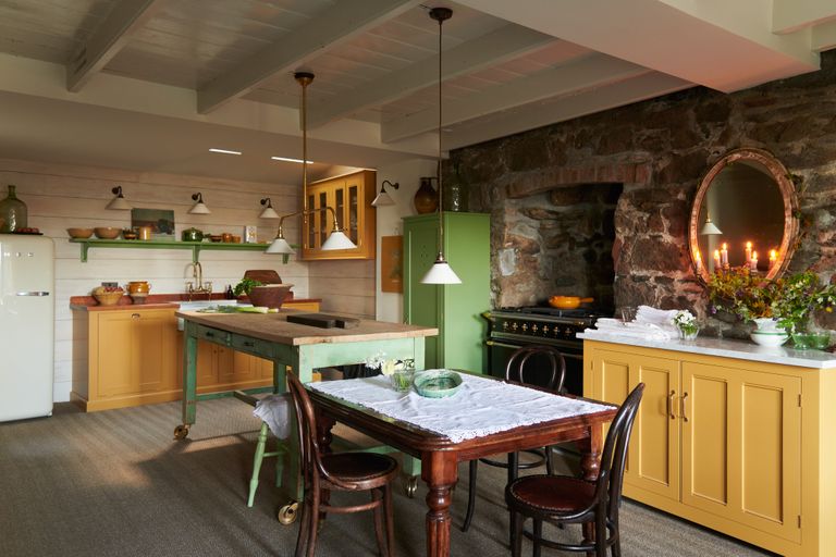 classic English kitchen with cream wooden wall and ceeling, stone wall, with themes of yellow and green throughout the room