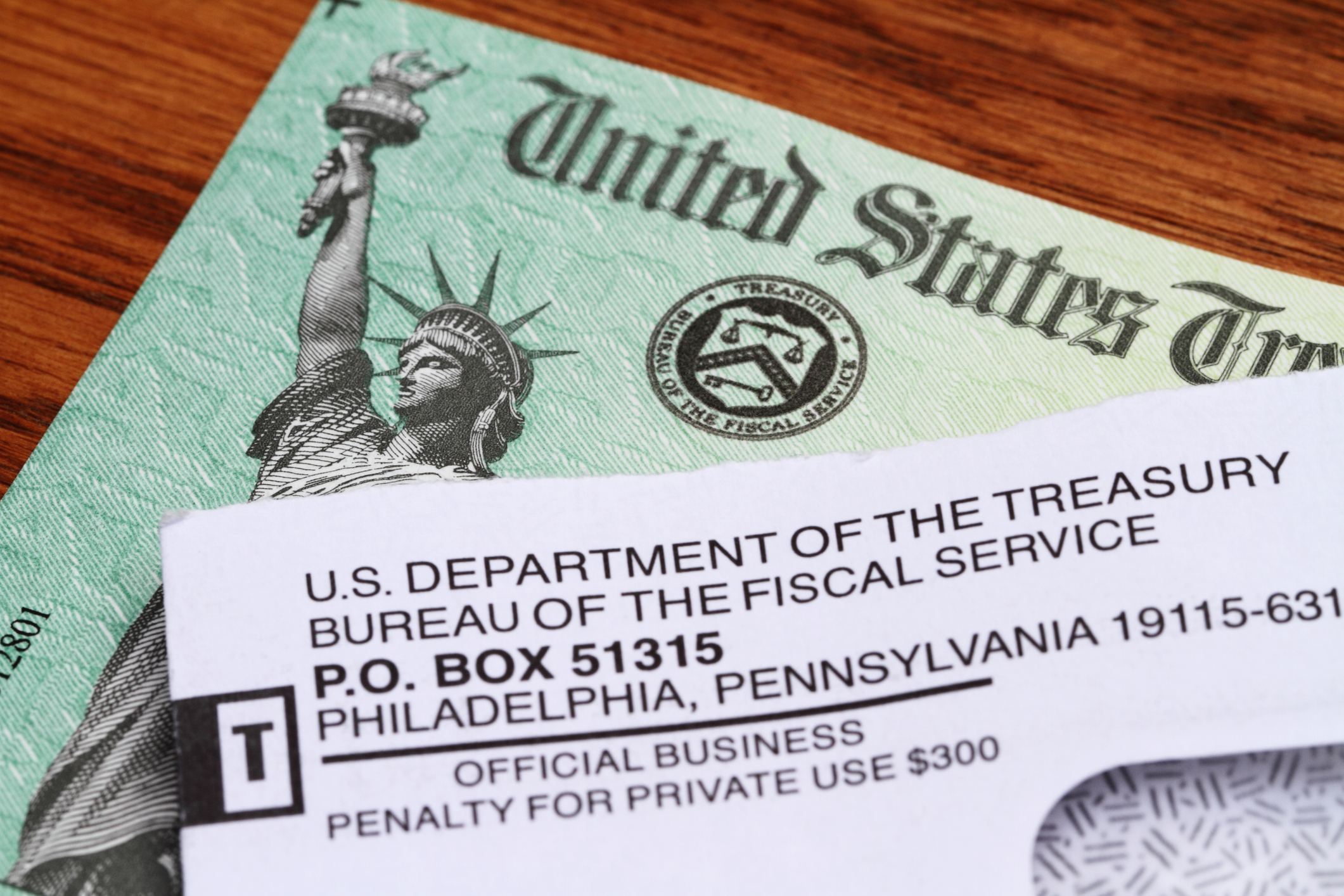 An opened envelope with the return address showing the U.S. Department of the Treasury lies on top of a An opened envelope with the return address showing the U.S. Department of the Treasury lies on top of a United States government Treasury Check. The distinctive green checks feature an engraving of the Statue of Liberty and the Treasury Seal. The government checks are used to disburse income tax refunds as well as Social Security and Medicare benefits.. The distinctive green checks feature an engraving of the Statue of Liberty and the Treasury Seal. The government checks are used to disburse income tax refunds as well as Social Security and Medicare benefits.