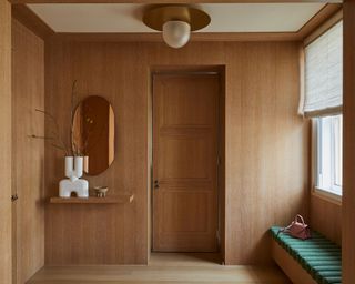 Modern wood paneled entryway with contemporary white vase and indoor tree by Paris Forino, Hudson Garruppo