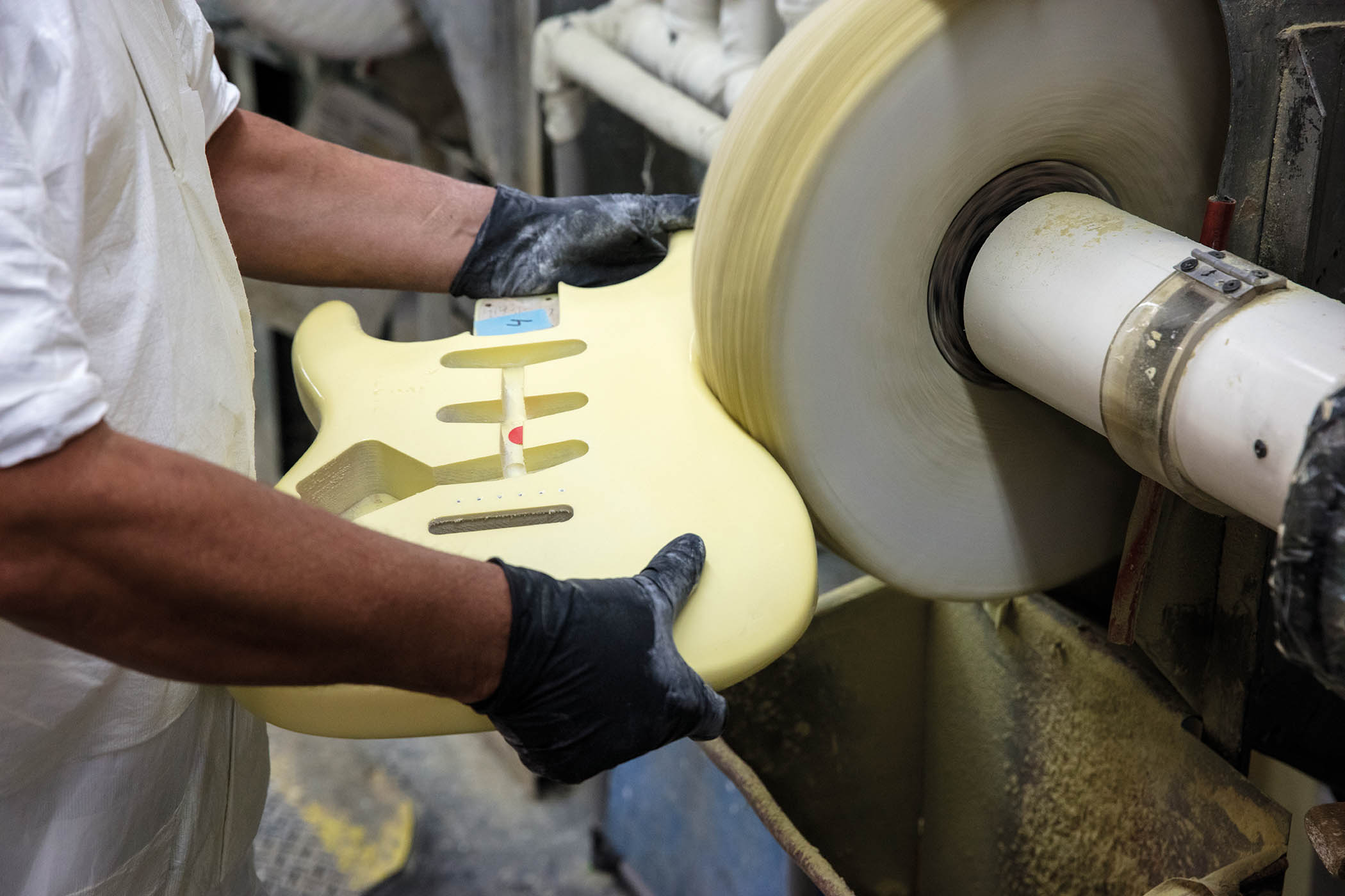 A luthier buffs a Stratocaster body at the Fender Custom Shop